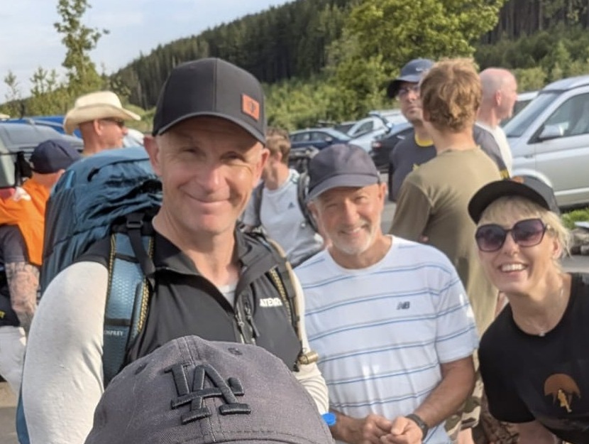 Neil in his black cap with friends at an outdoor event