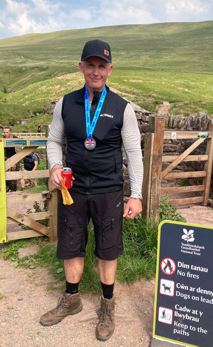 Neil Osborne after completing an outdoor endurance challenge, wearing his medal